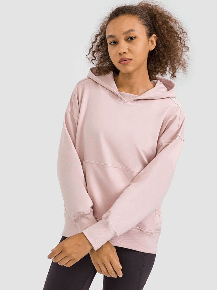 Woman wearing pink batwing sleeves hoodie for running, showcasing loose fit and hooded design.